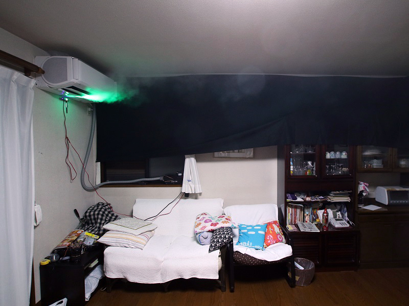 吹き出し口から出た重い冷気が、デュアルブラスターの気流に引き寄せられ天井を進んでいる(暗幕の上なので煙があまり写っていない)。ダイニングテーブルの上まで冷気が届いている