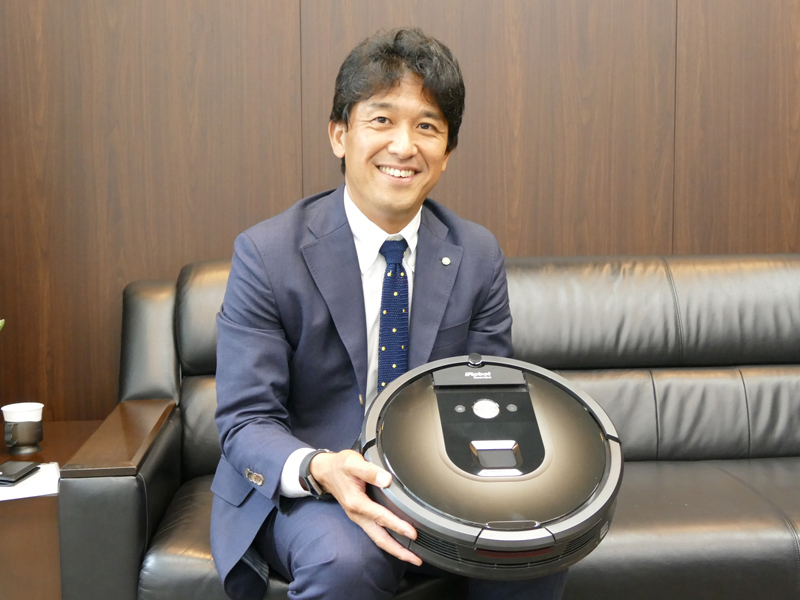 アイロボットジャパンの代表執行役員社長 挽野 元(ひきの はじめ)氏と、同社のお掃除ロボット「ルンバ 980」