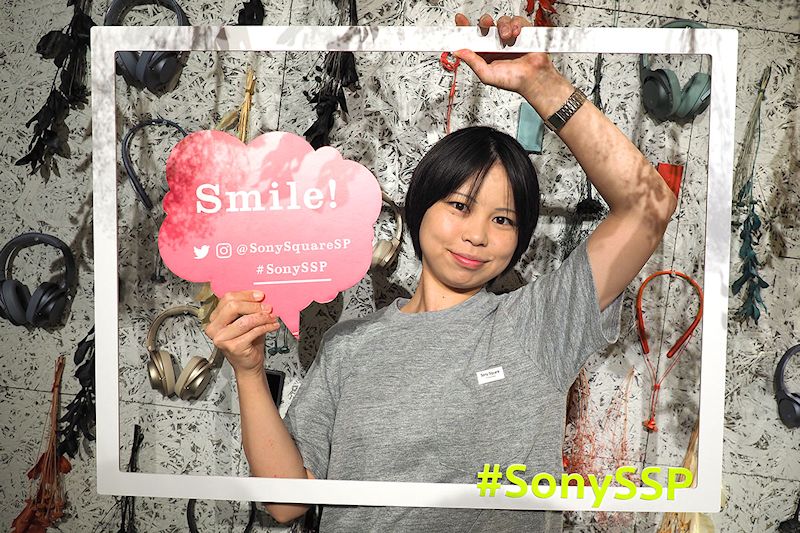 壁のカラフルな製品カラバリ展示の前で記念写真！　インスタ映えしちゃおう～、みたいな