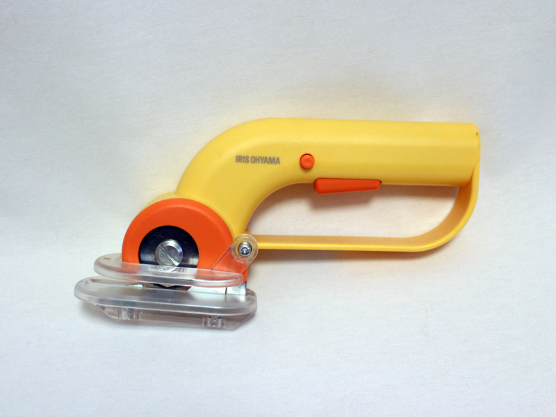 長さ、重さは500mlペットボトルほど。持ち手部分にロックボタンとスイッチ、先端にカッターがついている