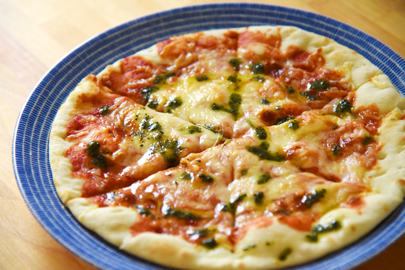 焼き上がったピザに付属のバジルオイルをかけてできあがり。ピザストーンのせいか生地もぱりっとして軽い食感