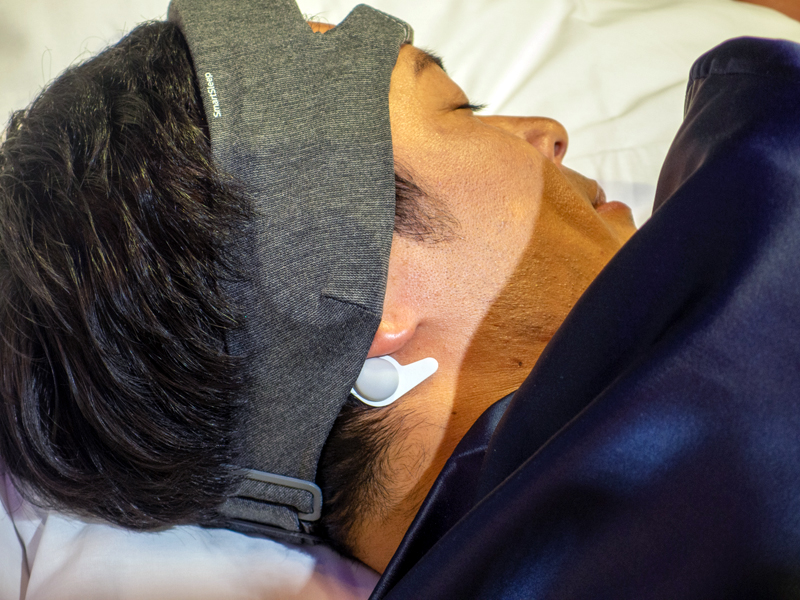 耳の後ろに脳波センサーをセットする