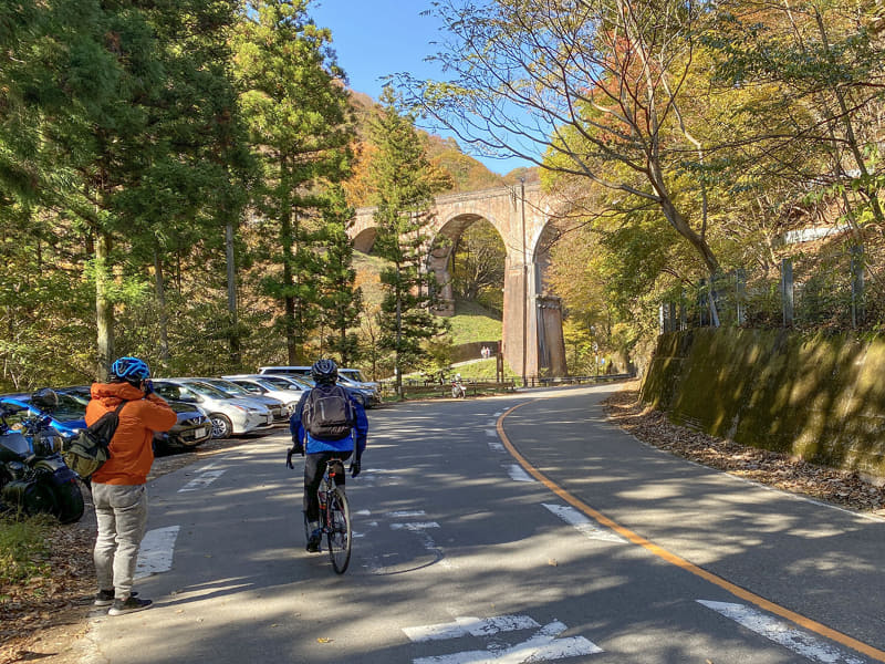 ひとっ走りで到着。向こうに見えるのが、めがね橋。その手前には、空き地に無理やり駐車しているクルマがたくさん! 平日なのに、です