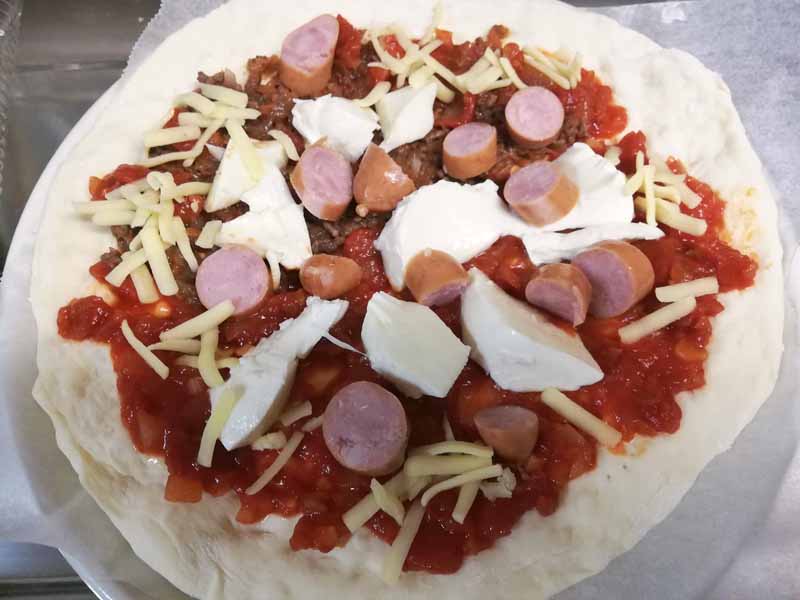 ピザは意外に簡単。トマトソースと、パスタに使ったポロネーズソースを使ってハーフ&ハーフに