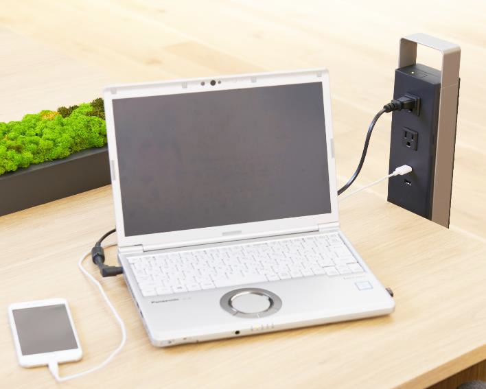 イーブロックスタンドをデスクのそばに置くと、コンセントやUSBポートがデスク横にある状態になる