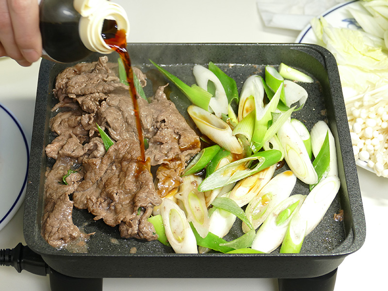 青ネギも加え、割り下を入れて焼き絡める