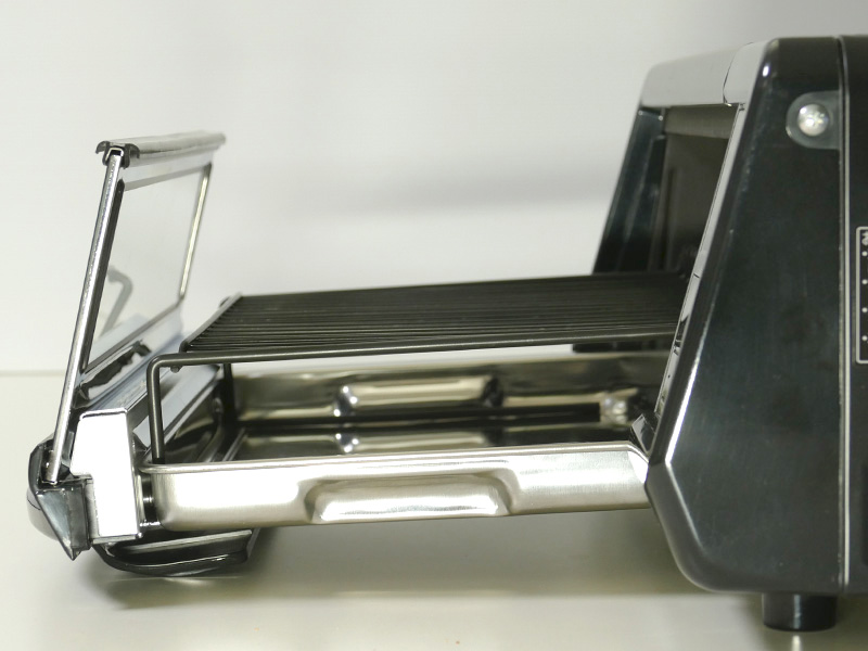 扉付きの受け皿を手前へスライドさせて開閉する。引き出したトレイは滑り落ちない構造があるが、奥行きのあるカウンター等の利用が望ましい