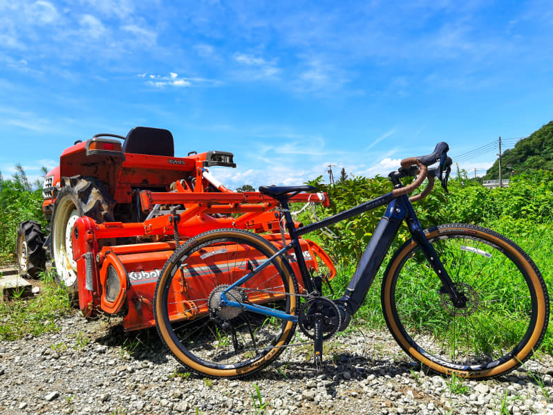 トラクターの前でグラベルロードe-bikeを記念撮影