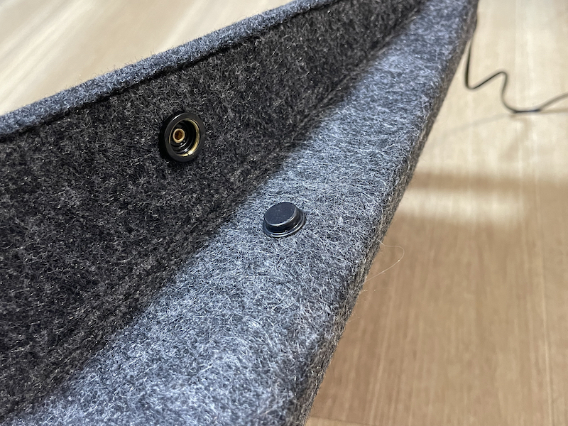 本体の左右の、マチを留めるホックを外す