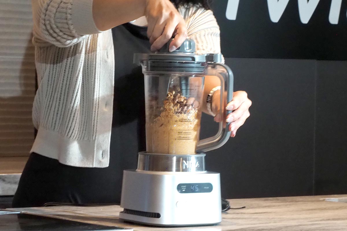 手でつまみを回転させる。ミキサーの回転とは逆方向に回し、運転中に上がってきた食材もしっかり混ざるようになる