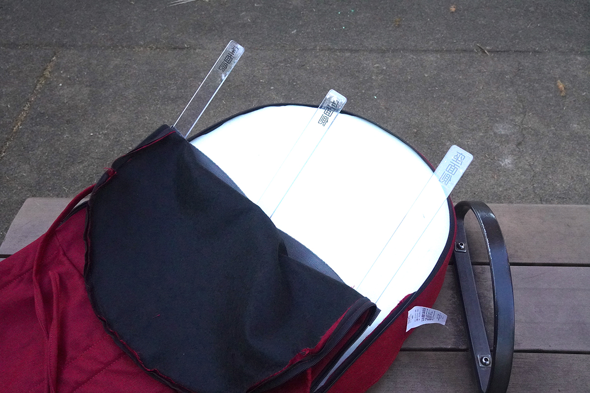 同梱されているプラスチックの棒を内側から差し込むことで、ふくらはぎに当たる布の角度が固定され、しっかりと温かさが感じられる。イスの背もたれに固定するヒモも備わっている