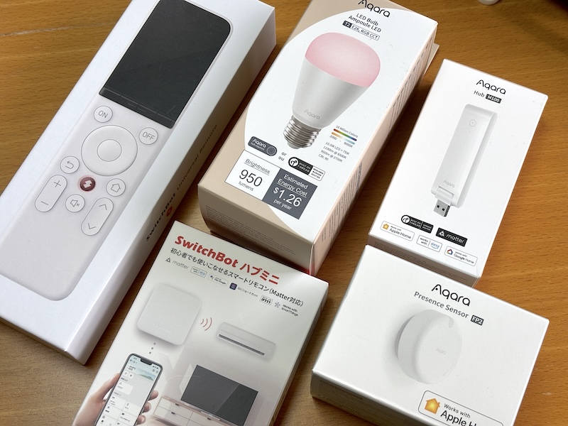 わが家で待機中のMatter対応デバイスたち。中央上から時計回りに、Aqara「LED電球 T2」「M100 ハブ」「人感センサーFP1E」、SwitchBot「ハブミニ」「学習リモコン」。これを機に設定していきます