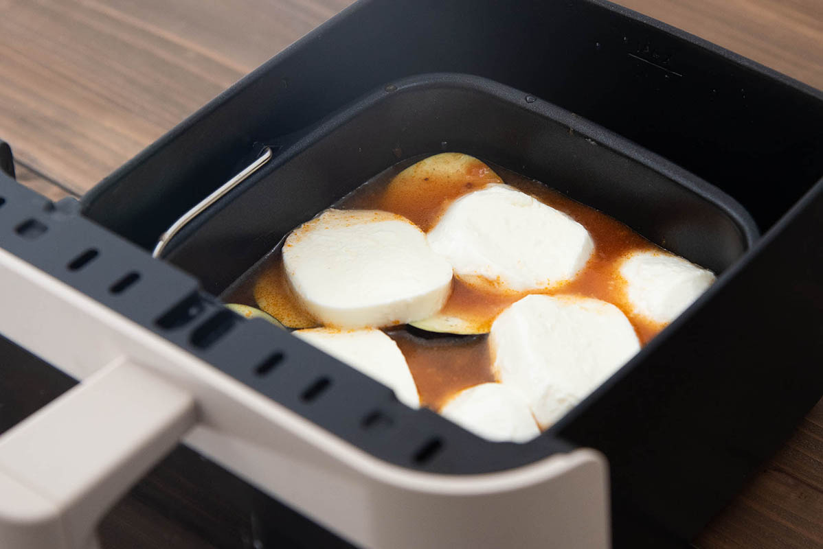 パスタと水、ソースを入れてよく混ぜ合わせてから、なすとモッツァレラチーズをその上にのせます