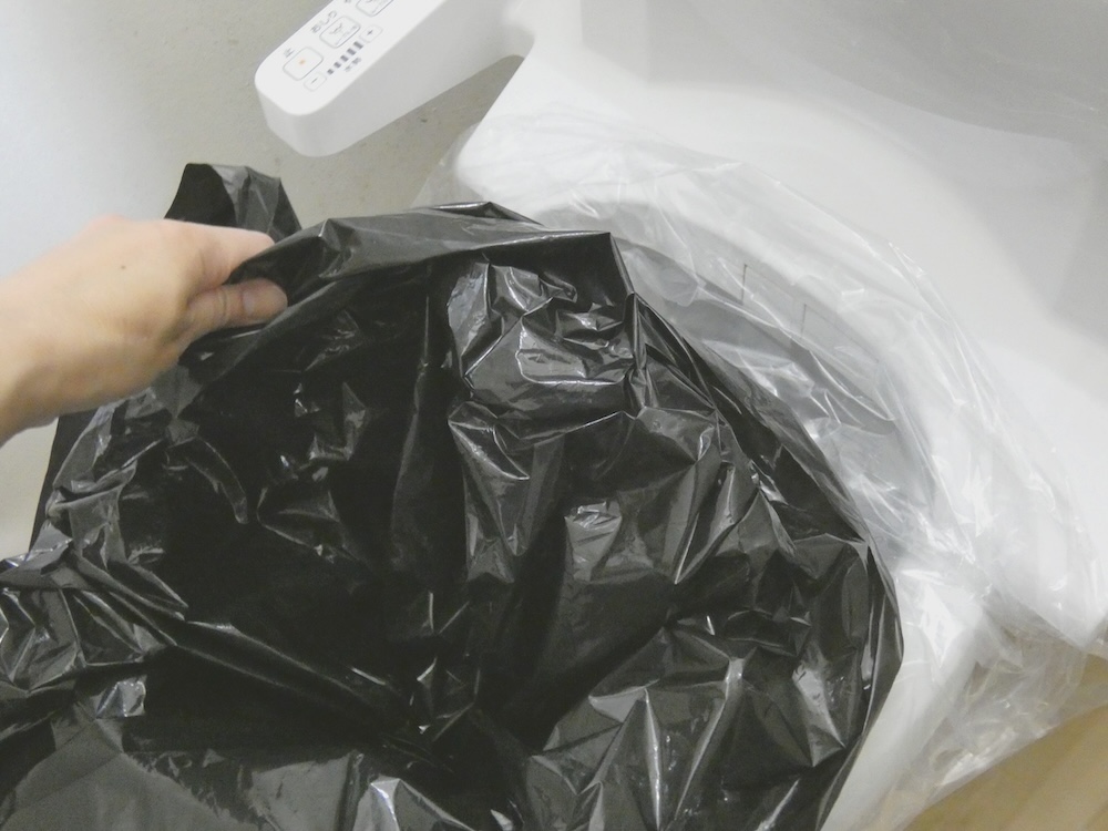 便器カバーの上に黒の汚物袋をセットする