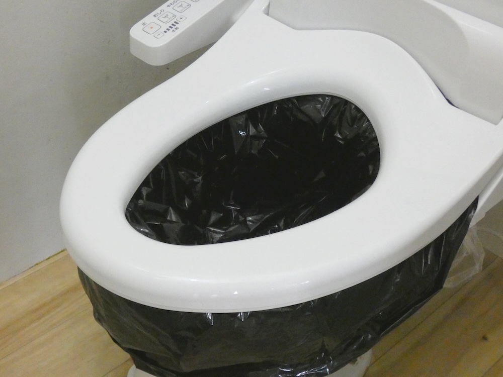 便座を下ろして袋を固定する