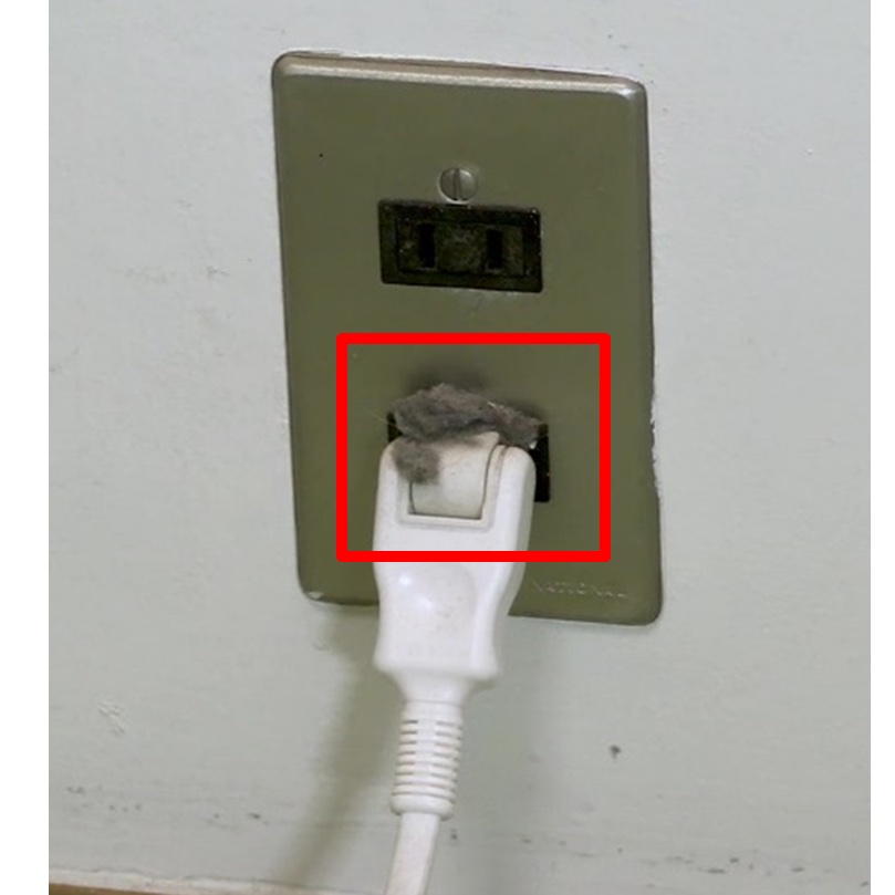 コンセントに差し込んだプラグ周辺にほこりが溜まっている様子