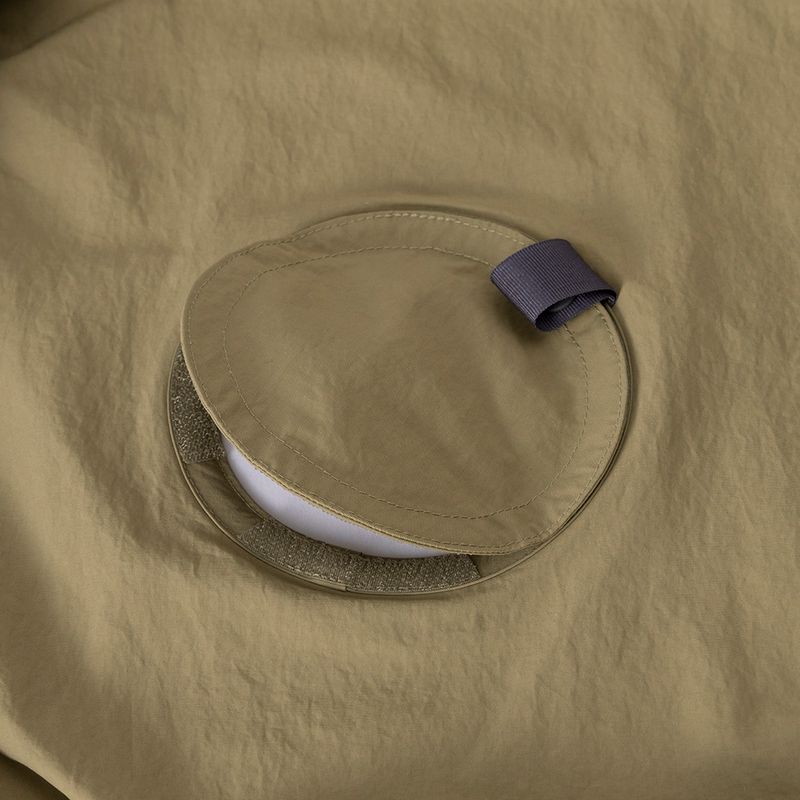 「ファンブロー」シリーズ・ウェアにはファンを取り付けるための穴が開いています。この穴は付属の同色ファブリックのカバーで塞ぐことができます。ファンが必要ないときは、ファンを外してカバーを装着することで、アウトドアウェアとして利用できます。ただしカバーとウェアの間には少々の隙間ができ、完全に塞がるわけではありません(画像：モンベルオンラインストア)