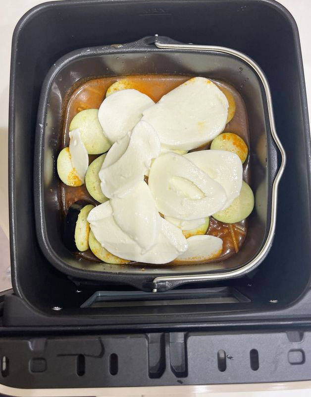 付属のインナーポットに水を入れたら、パスタを半分に折って入れ、市販のミートソース、ナス、スライスしたモッツァレラチーズの順に入れるだけで準備完了