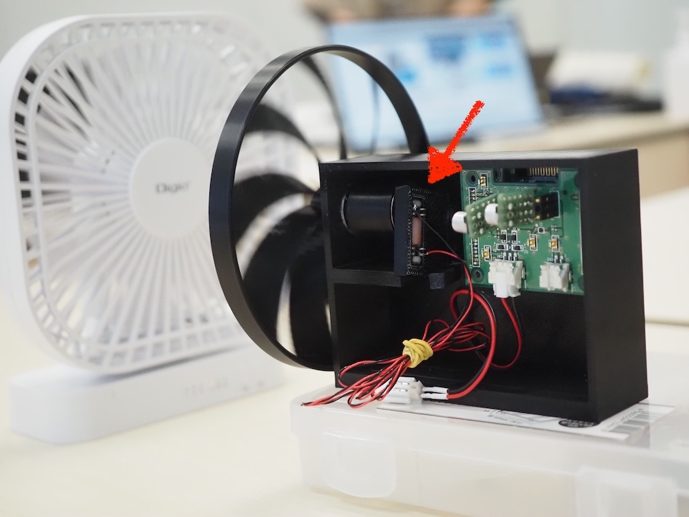 「電磁誘導環境発電技術」の発電モジュールを実装させた風力発電装置。矢印の先のパーツが、発電モジュール