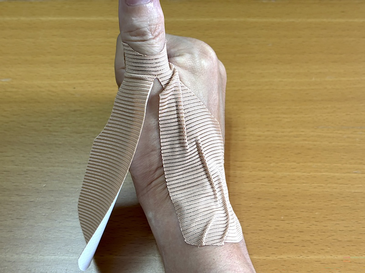 ステップ2。親指を立てて手首をまっすぐにした状態で右側の部分を手の甲に貼り付ける