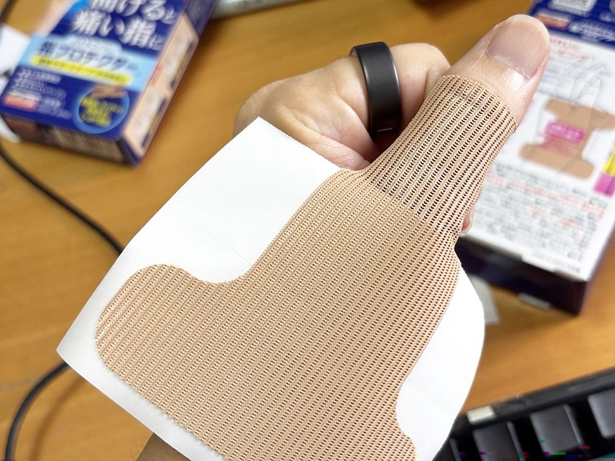 ステップ1。小さい方の剥離紙を剥がし、まずは親指の第1関節に貼り付ける