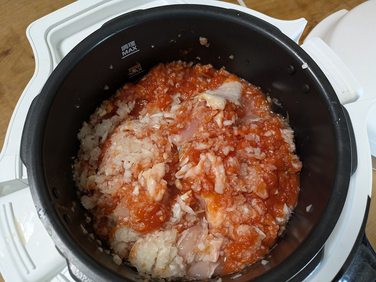 みじん切りした玉ねぎ2つ、トマト缶、鶏もも肉、おろしニンニク、バター、ハチミツ、塩こしょう、コンソメ、カレー粉などの材料を全て投入。後はスイッチを入れるだけ!