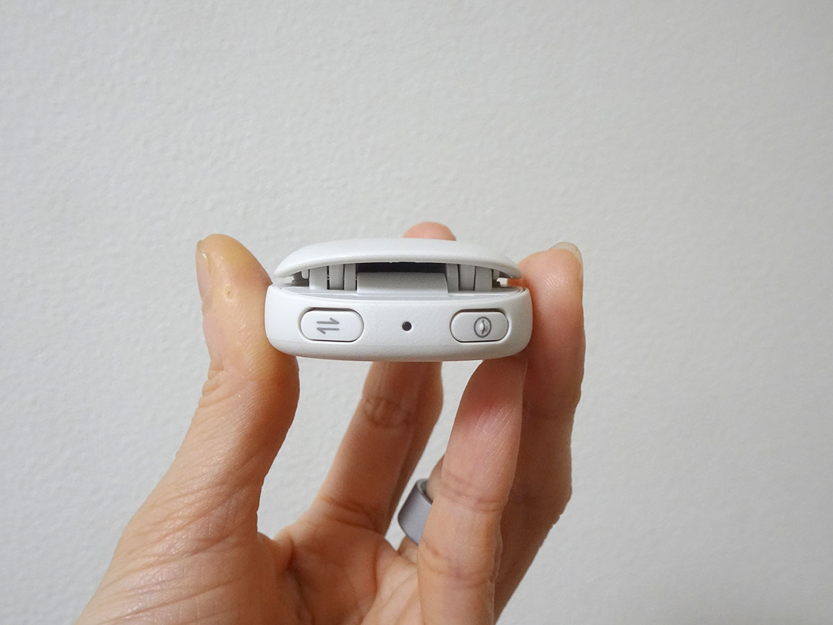 クリップのヒンジ側に電源とデータ転送用のボタンを装備。装着前に右側の電源ボタンを必ず押しておく。起床後は左側のデータ転送ボタンを押してスマホアプリと同期する。中央のLEDランプで電源オンやデータ転送中であることを確認できる