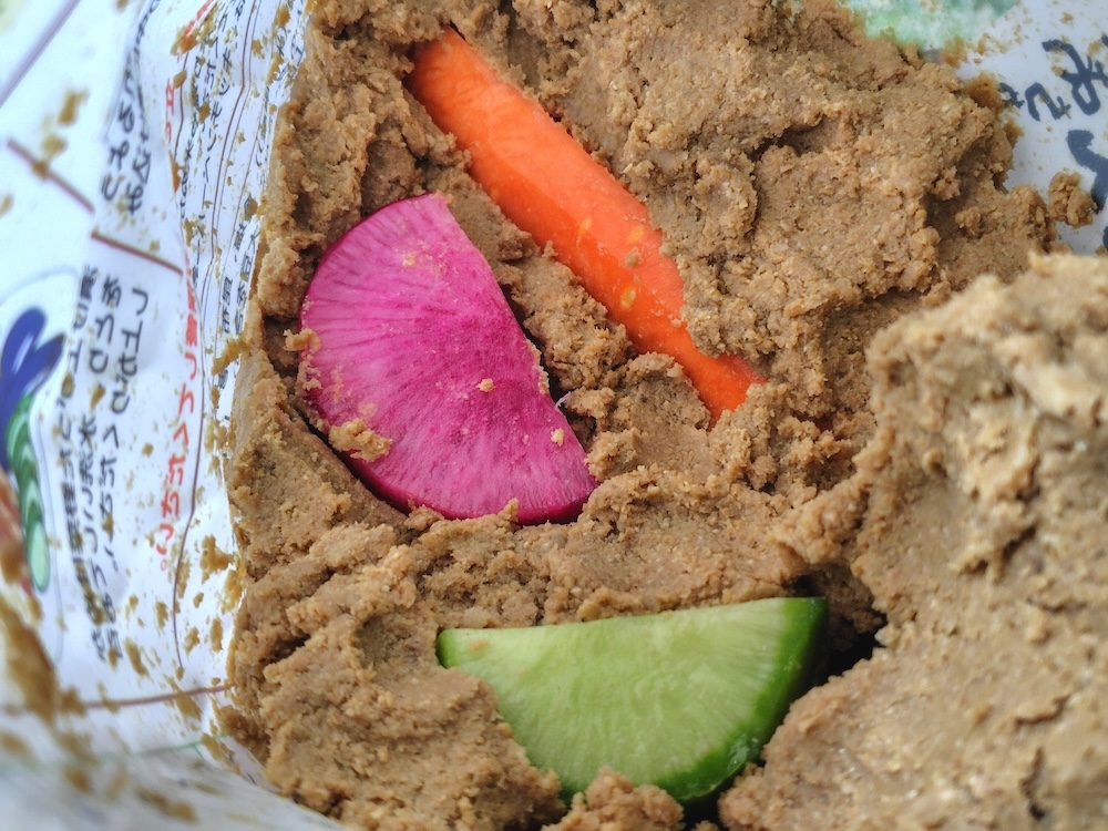 スタンドパックを広げながらぬか床をならして野菜を入れる