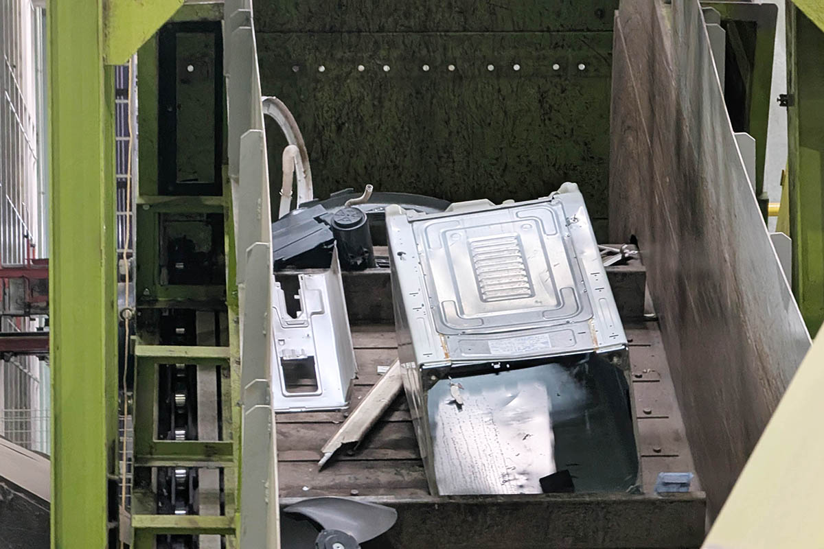 洗濯機の外板やエアコンの室外機のファンが見える。まとめて粉砕機にかけられ細かなチップとなり、自動的に素材ごとに分離される