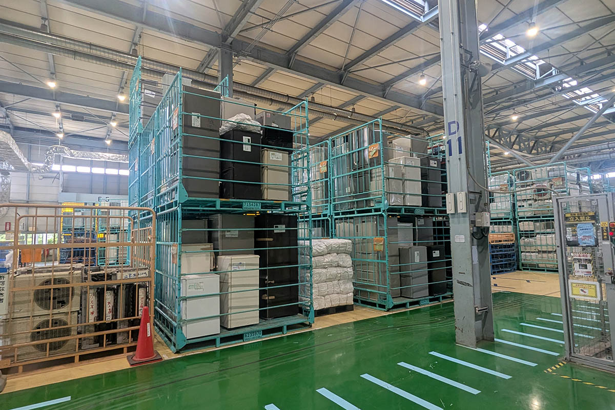 リサイクル処理を待つエアコンや冷蔵庫、洗濯機がうず高く積まれている。十年近く活躍してきた家電は、素材に戻り第二の生を歩むことになる