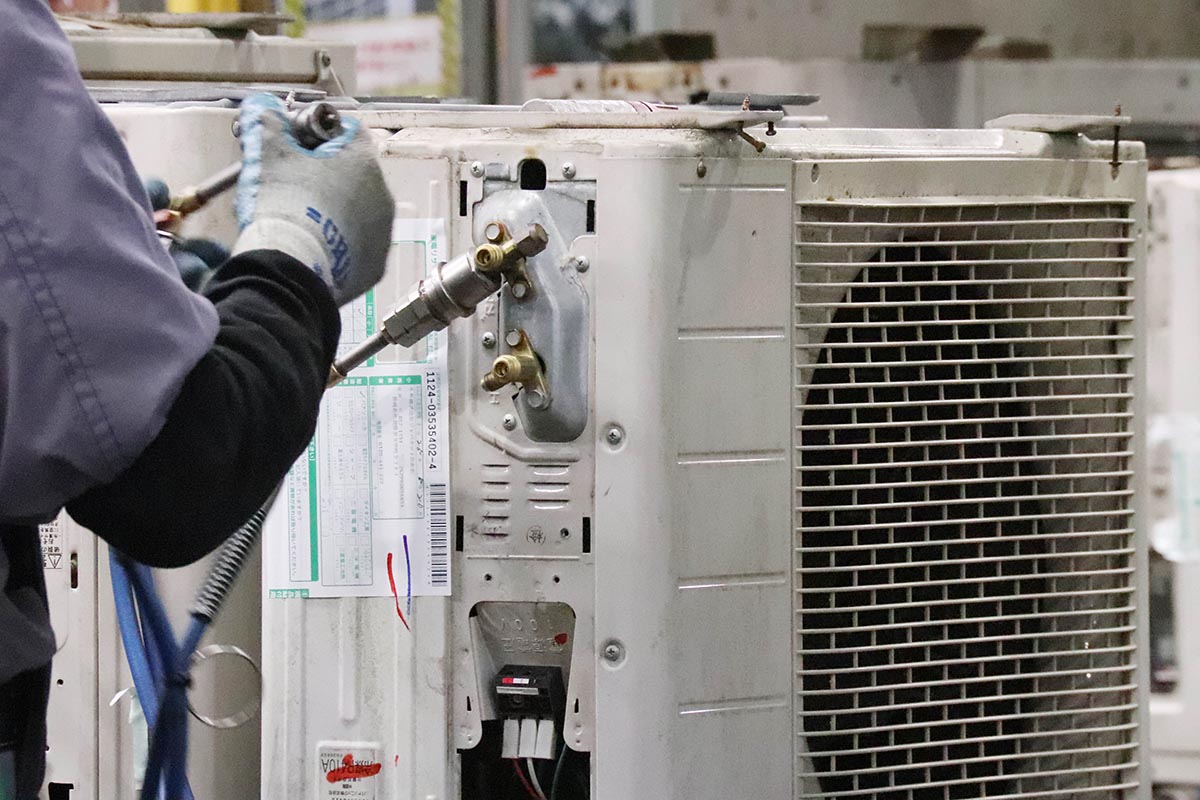 ガスの出入口に管を接続し、中に封入されている高圧ガスを回収する