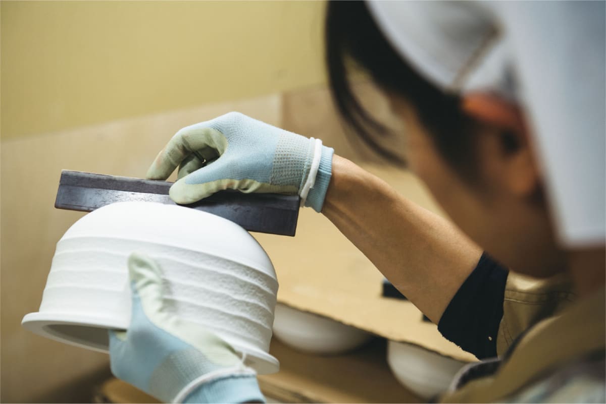 工場では、一次焼成、釉薬焼成、IH発熱体を貼り付けた後の仕上げ焼成と3段階を経ることで、寸法の安定化や表面強度の均一化を実現