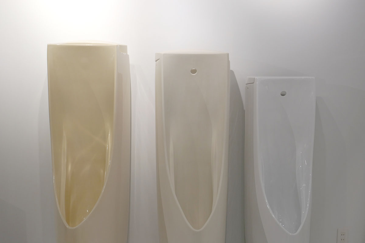 画像左が乾燥前の男性用小便器模型。天面を膨らませている。中央が乾燥後、右が焼成後。カーブしていた天面は乾燥させて焼くことで平らに