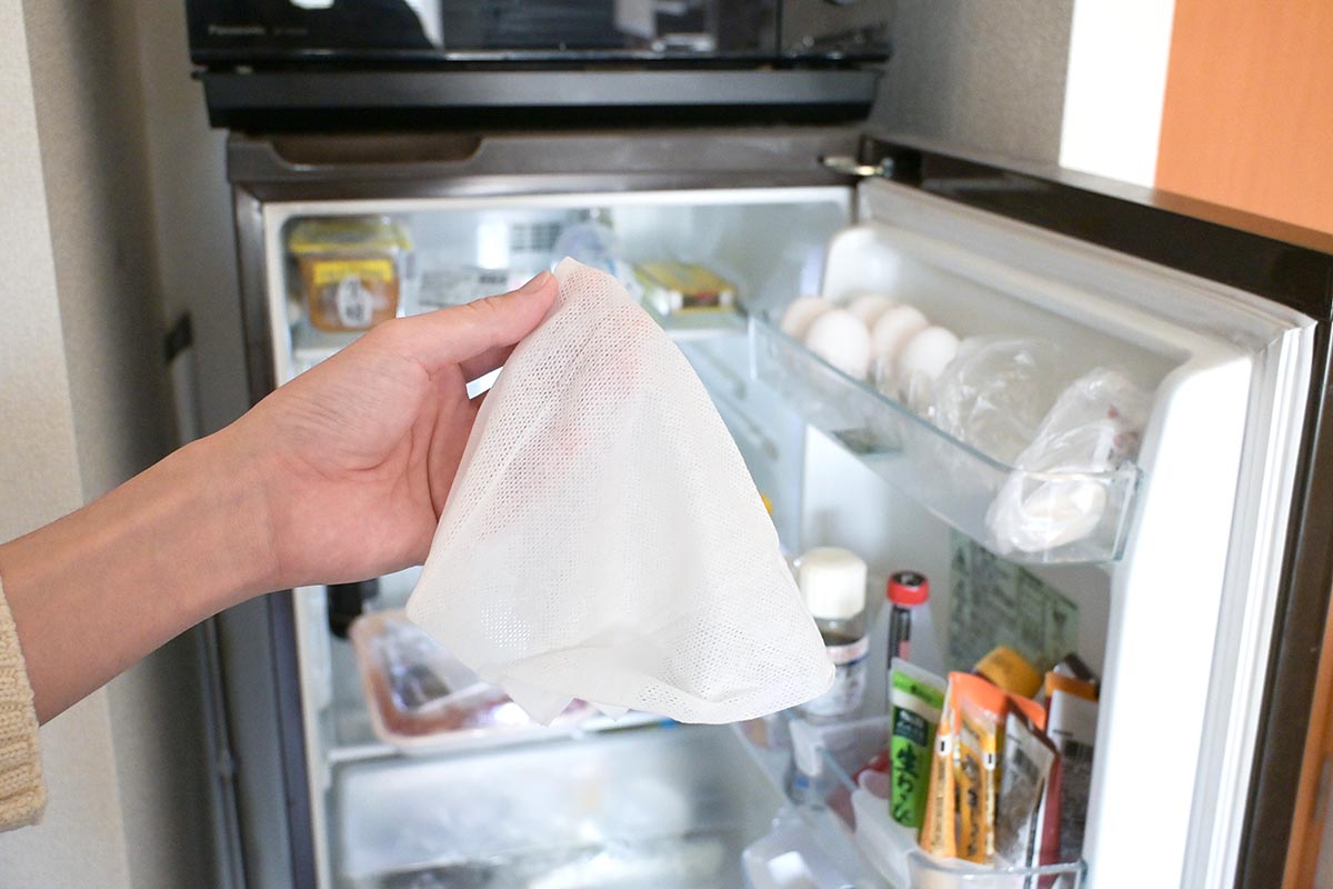 冷蔵庫から食材を取り出し、空の状態にしてシートで拭き掃除