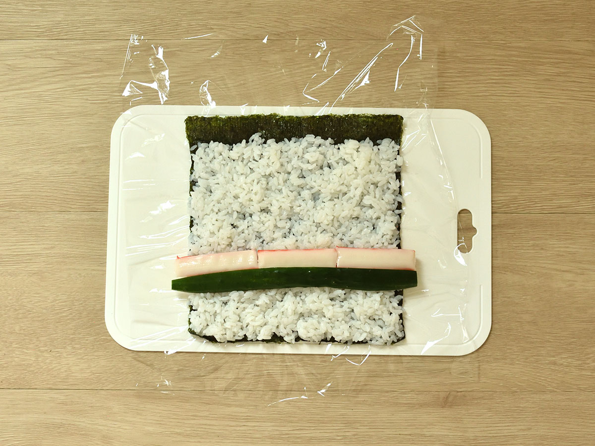 キュウリとカニ風味かまぼこを酢飯に並べます