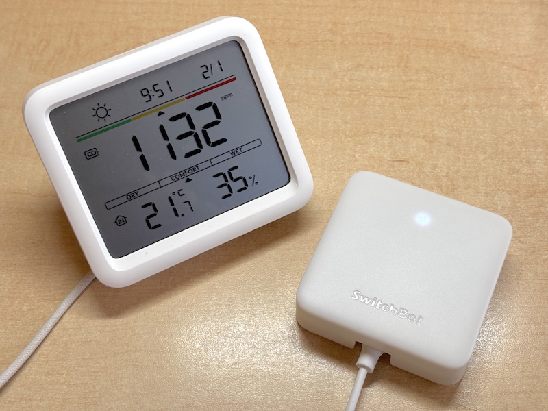 「SwitchBot CO2センサー(温湿度計)」(左)と「ハブミニ」(右)。単体でも温度、湿度、CO<span class="em sub">2</span>濃度などは表示するが、ハブミニと接続することでスマホ通知や天気予報表示に対応する