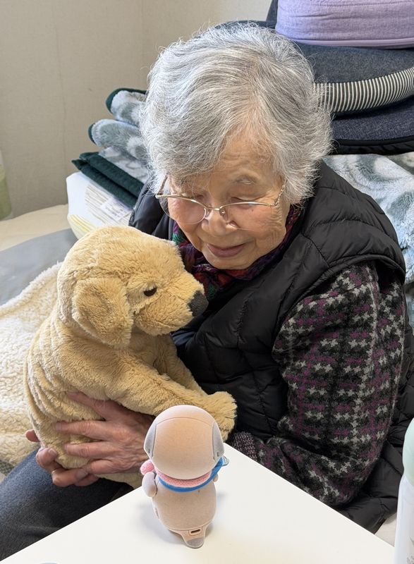 シャープの「ポケとも」(写真手前)と接する筆者の義母。これからのロボットは、人にとってどんな存在になっていくのでしょうか