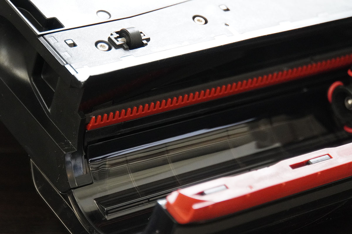 ヘッド内のブラシを外したところ。長い髪などは、奥に見える赤いギザギザのパーツでカットして吸引します。第三者機関による測定では髪のカット率は100%なのだそう。筆者は背中までのロングヘアなのでかなりありがたい