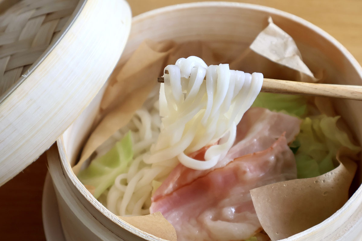 「蒸しうどん」完成! もちろん普通の切り落とし肉でもいいのですが、うどんにベーコンの塩気がなじむと美味しいのでオススメ