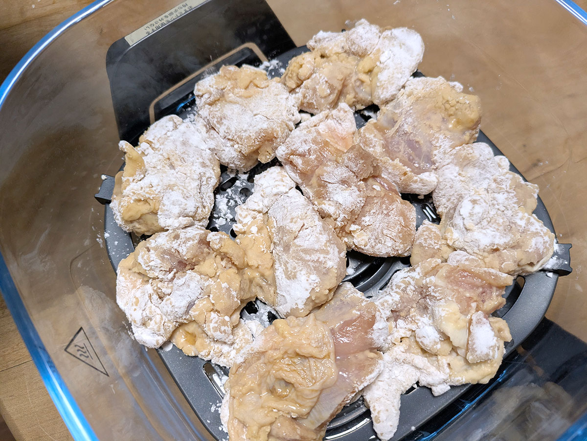 下味をつけた鶏肉に片栗粉をまぶしてコンテナにセット