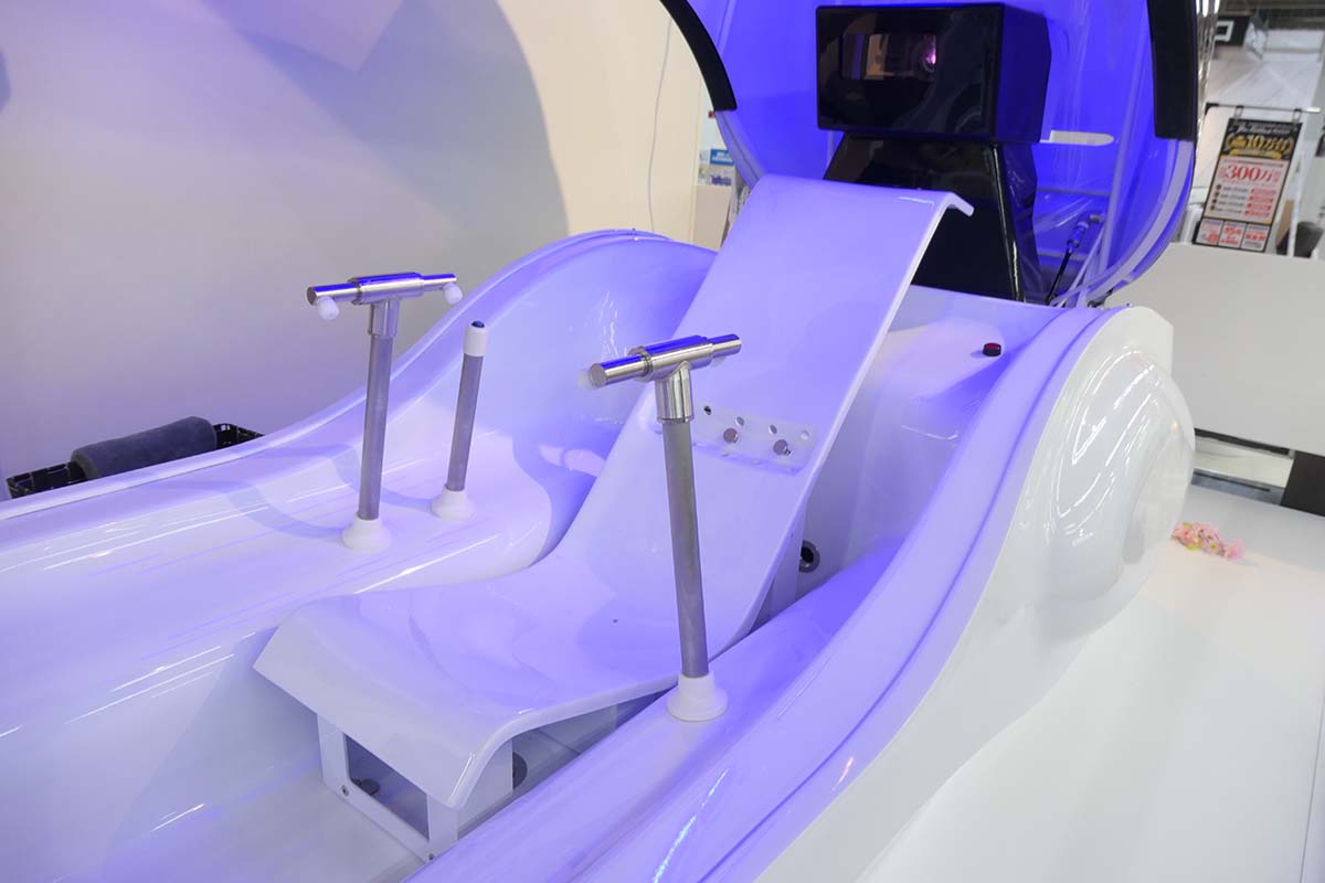 内部にはリクライニング姿勢で座れる椅子があり、両サイドには上半身を洗浄するためのノズルが備えられています