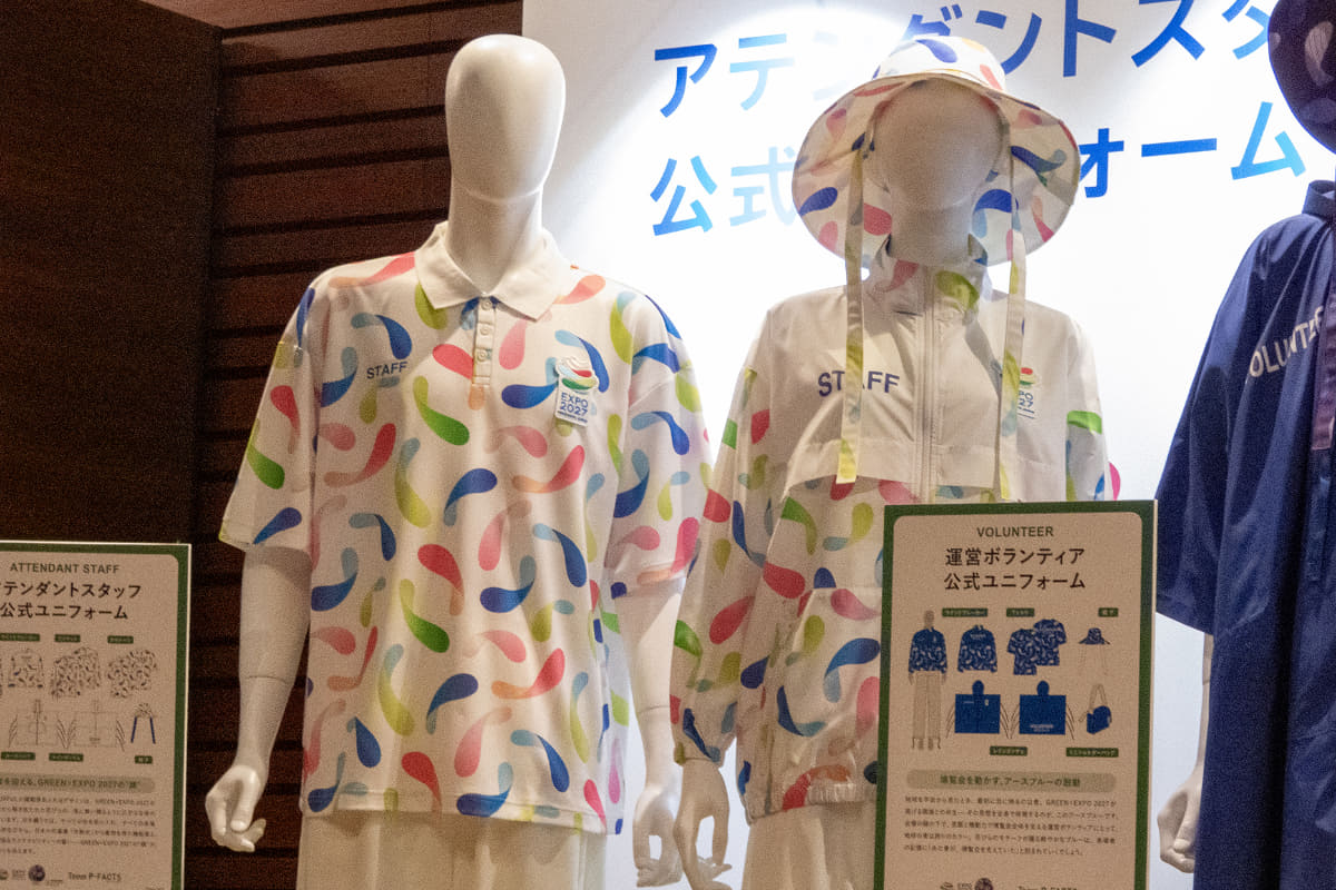 アテンダントスタッフ公式ユニフォーム<br>GREEN×EXPO 2027のシンボルマークから解き放たれた花びらが、風に舞い踊るように広がる生命の喜びを表現。白をまとうのは、すべての色を受け入れ、すべての来場者を迎え入れる存在で、日本の作業着「作務衣」から着想を得た機能美と、生分解性素材が語るサステナビリティへの誓いが込められています