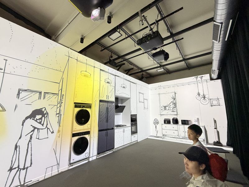 線画の空間に光や映像が重なり、暮らしの情景が浮かび上がっていく演出。近くにいた親子連れも一心に見つめていたのが印象的だった