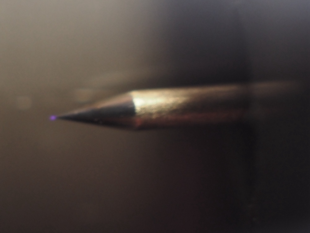 電極(針)を拡大すると、電極の先端が紫に光っている。イオンが放出されている?