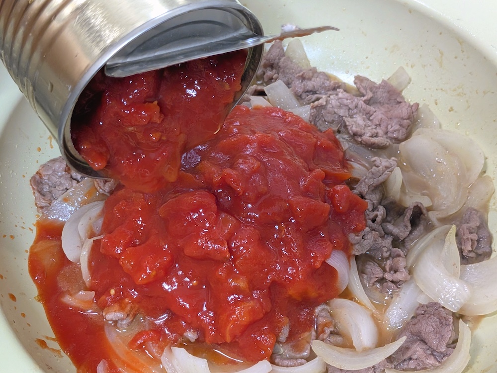 玉ねぎがしんなりしたらトマト缶を加えて加熱