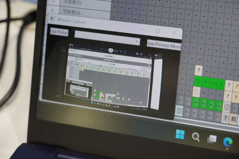 グラスの表示内容がノートパソコンの画面下部に映っている様子
