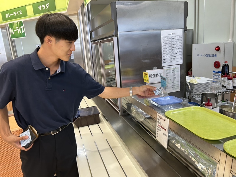 学食券を窓口に提出して注文する学生