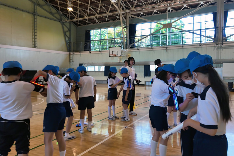 2人1組でデジタル端末の装着をお互いに手伝い