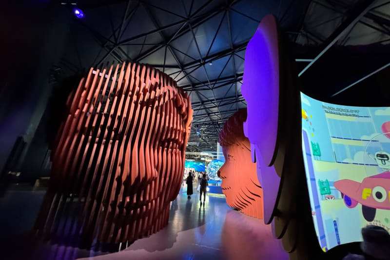 巨大な頭部型の装置が並ぶ「未来の都市探訪」。アニメ映像で未来の生活をイメージする。映像は4種類あり、それぞれ順次再生される