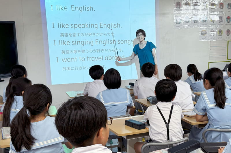 先生の後に続き「because」を使った表現を練習する児童たち